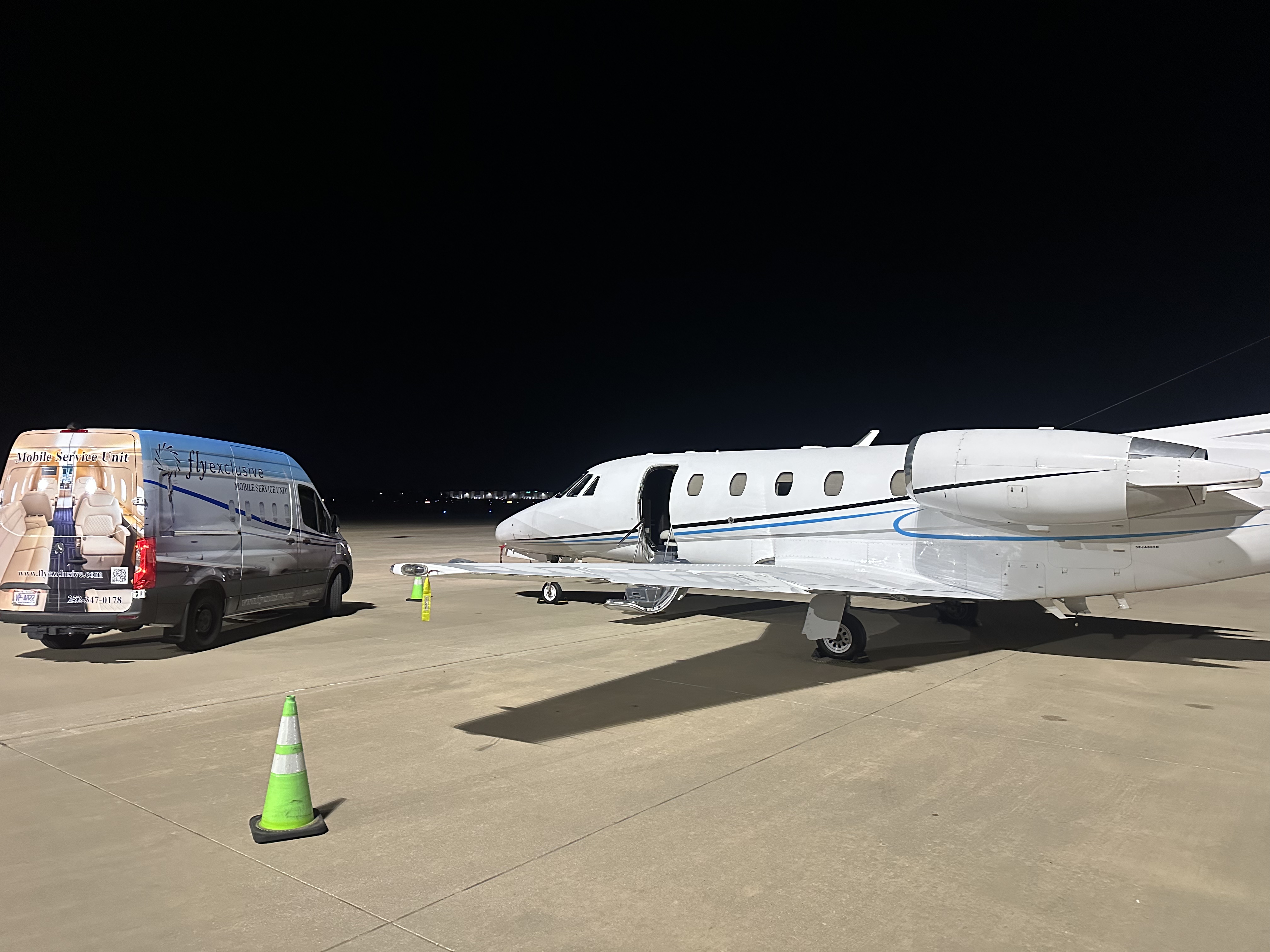A flyExclusive technician working at the aircraft on the ramp