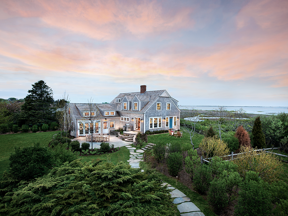 An Inspirato residence above a wooded valley at dusk