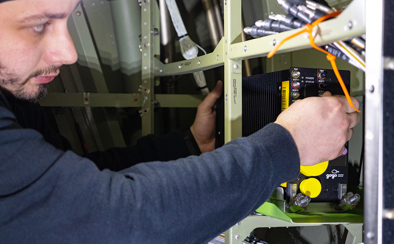 An avionics technician working on an aircraft panel