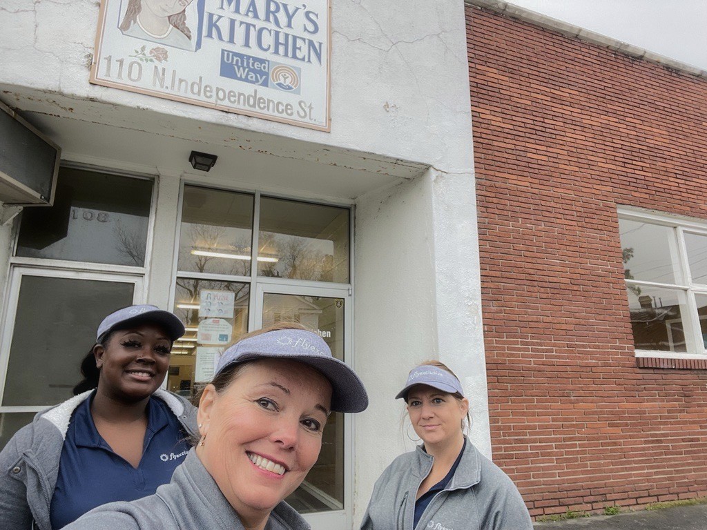 Three flyExclusive employees in branded caps outside Mary&rsquo;s Kitchen in Kinston, North Carolina