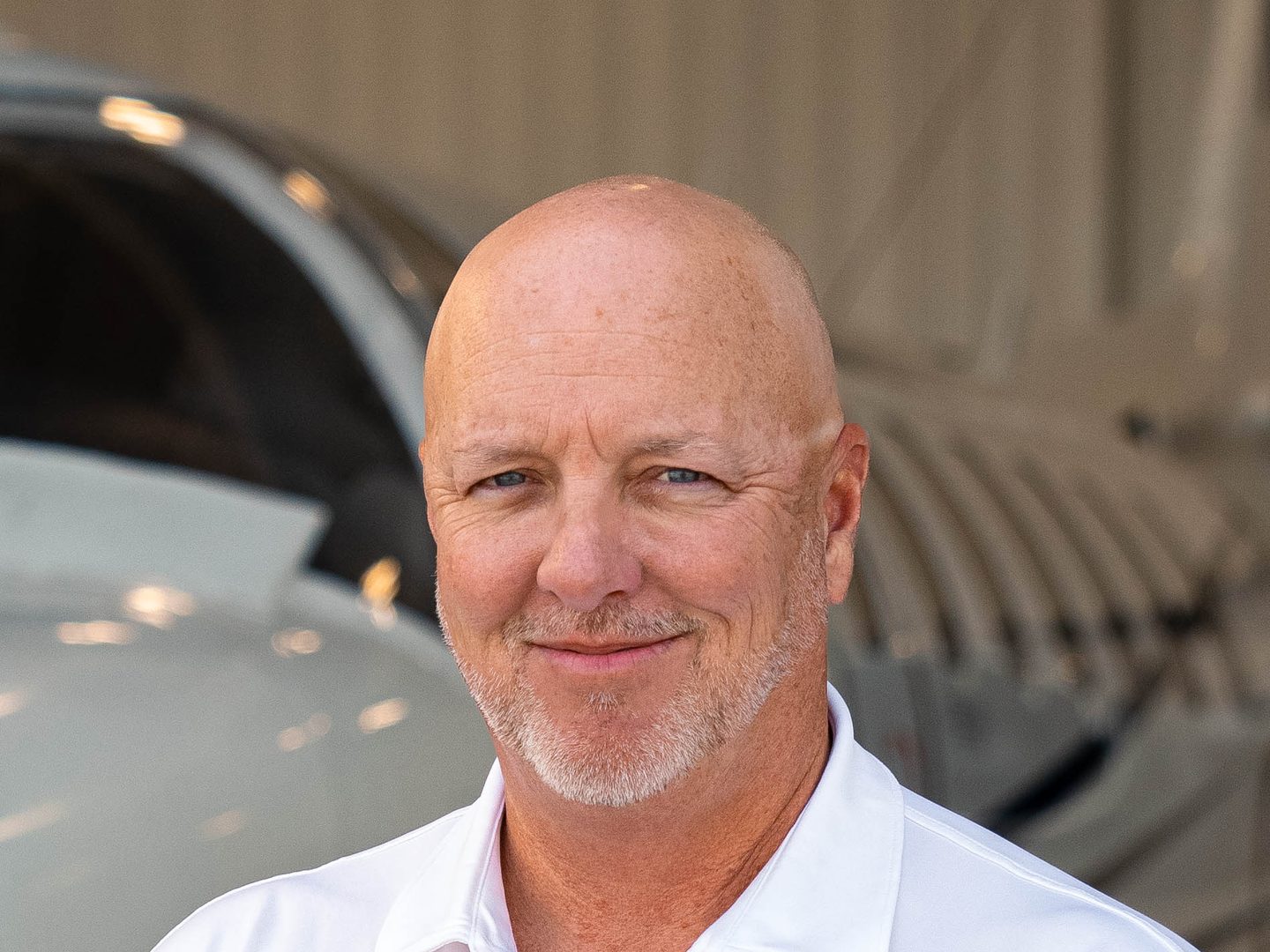Jim Segrave in a flyExclusive polo in front of a Citation in the hangar