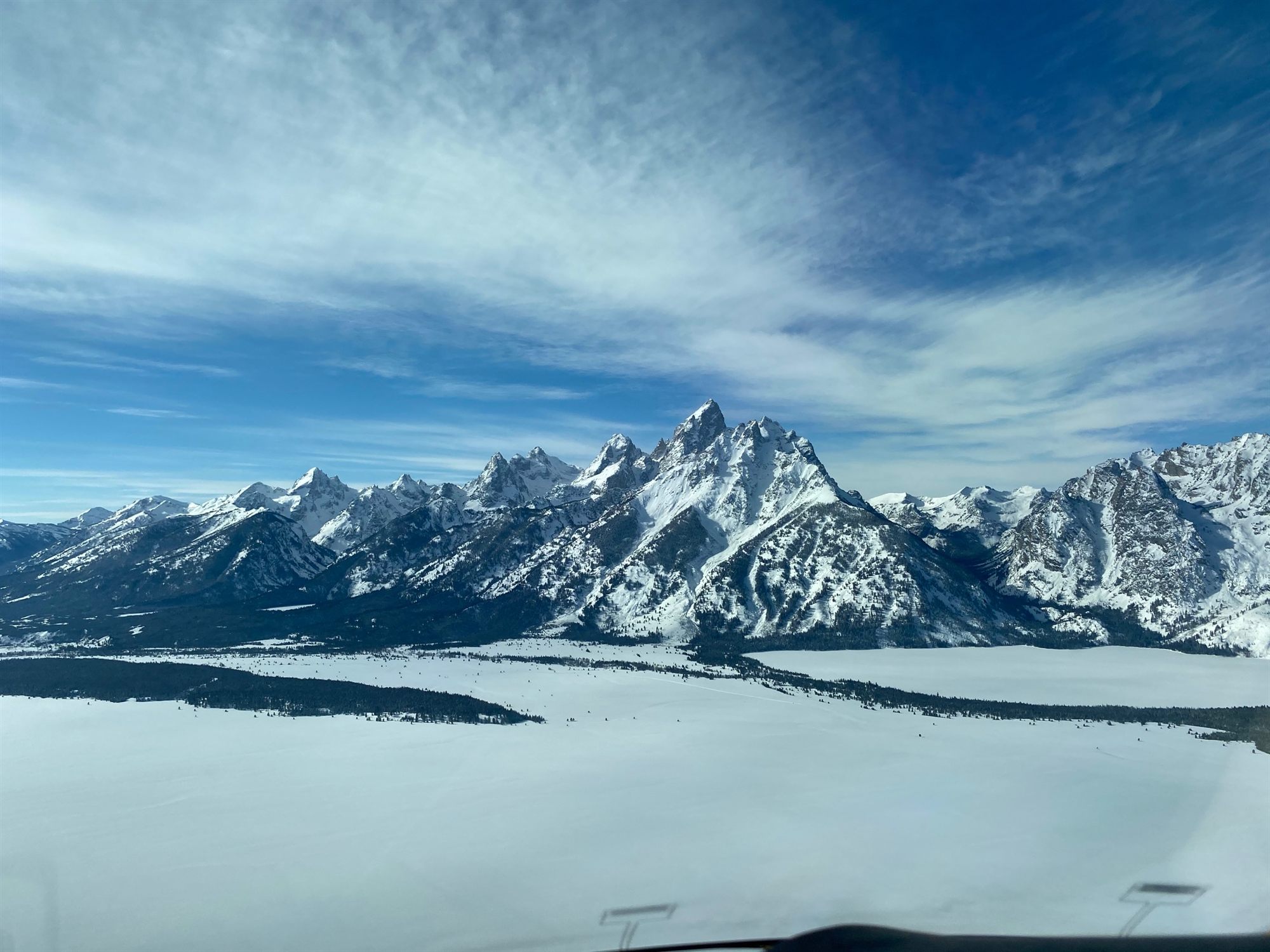 The Tetons under snow, seen from a flyExclusive cabin window